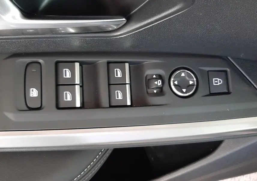 Vue rapprochée de la commande des vitres et rétroviseurs sur la porte côté conducteur du Peugeot 3008 bleu Ingaro 2025.