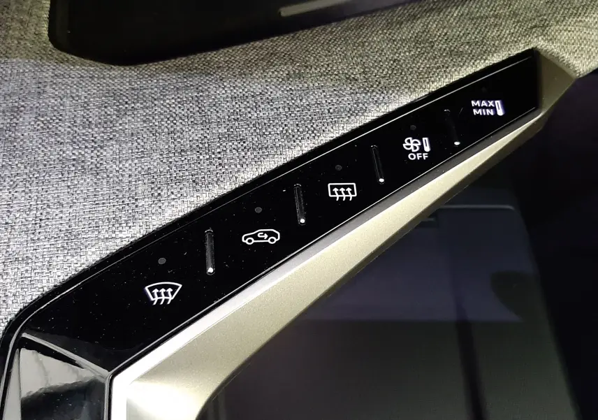 Détail du panneau de commande de climatisation tactile dans l’habitacle du Peugeot 3008 hybride 2025, finition GT.