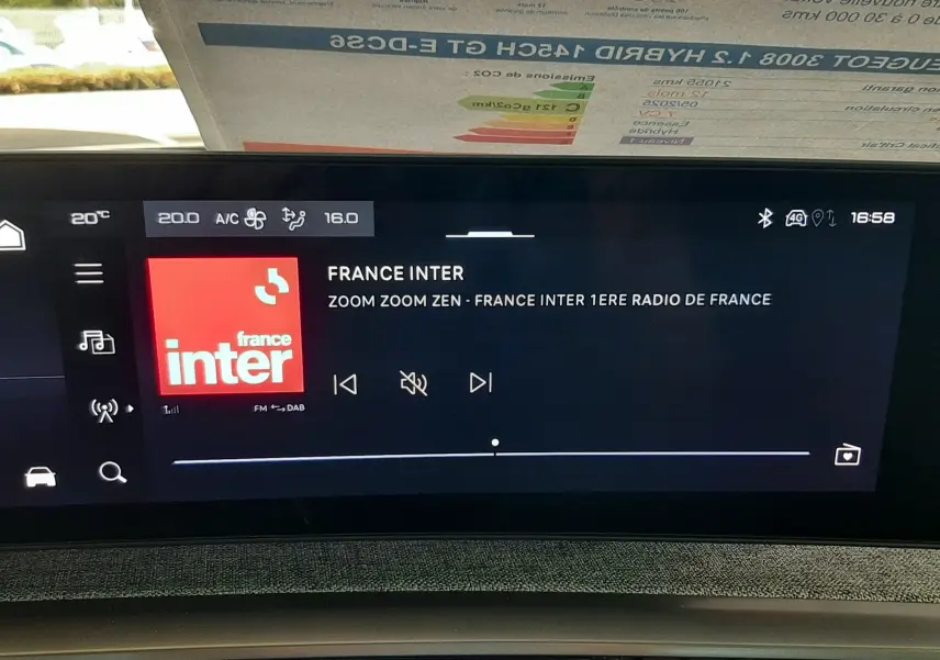 Écran tactile central du Peugeot 3008 Hybrid 2025 affichant la radio France Inter, avec bouton start/stop et commandes climatisation visibles.