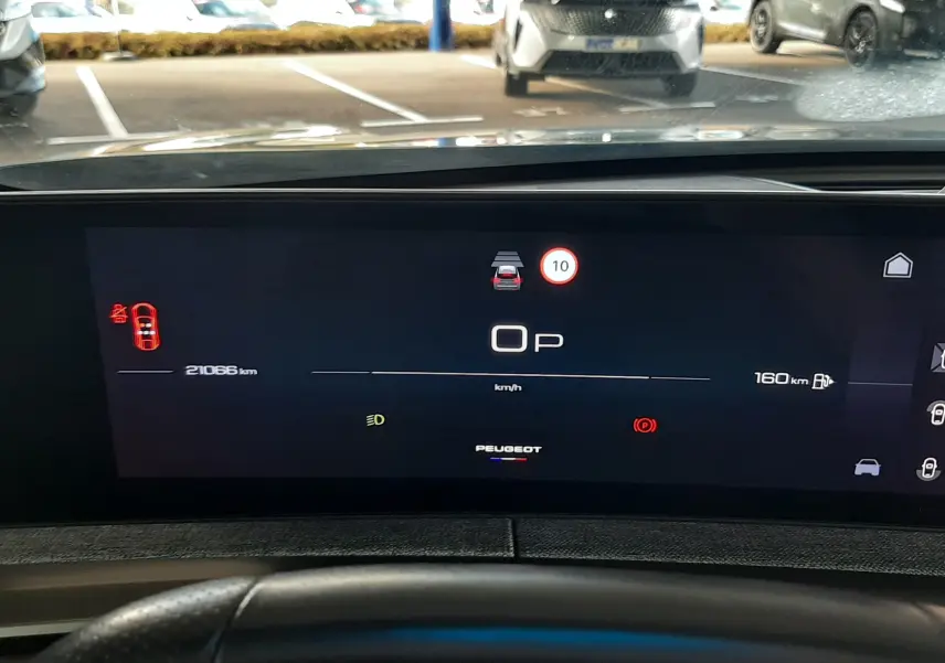 Vue intérieure du tableau de bord numérique du Peugeot 3008 bleu Ingaro, affichant la vitesse à 0 km/h et divers voyants allumés.