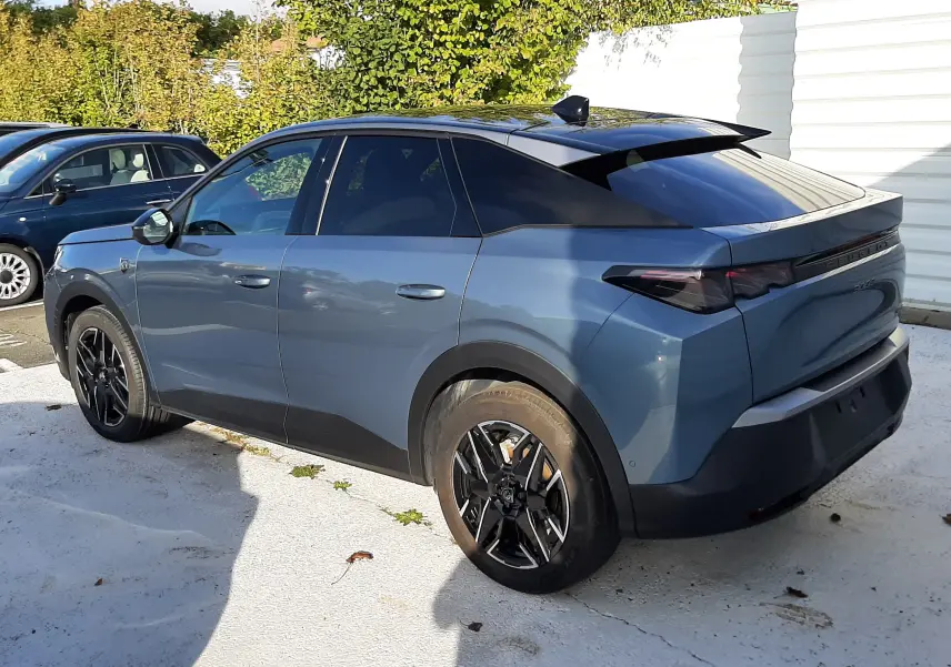 Peugeot 3008 1.2 Hybrid 145ch GT bleu Ingaro en 3/4 arrière droit, toit noir et jantes noires distinctives.