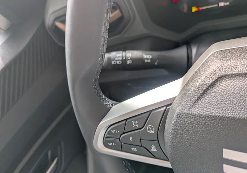 Gros plan sur le volant multifonction du Dacia Bigster Hybrid 155 Extreme, avec commandes intégrées et tableau de bord partiel.