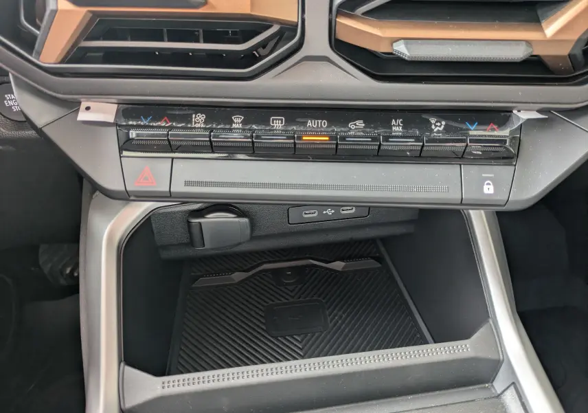 Vue rapprochée de la console centrale du Dacia Bigster Hybrid 155 Extreme, avec commandes climatisation et ports USB visibles.