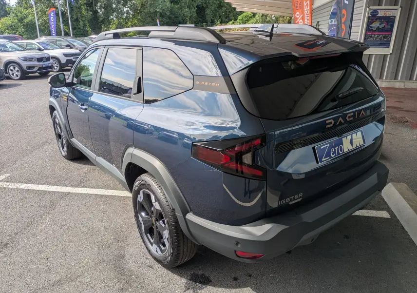 Vue 3/4 arrière droite du Dacia Bigster Hybrid 155 Extreme bleu indigo avec jantes alliage noires et hayon électrique.