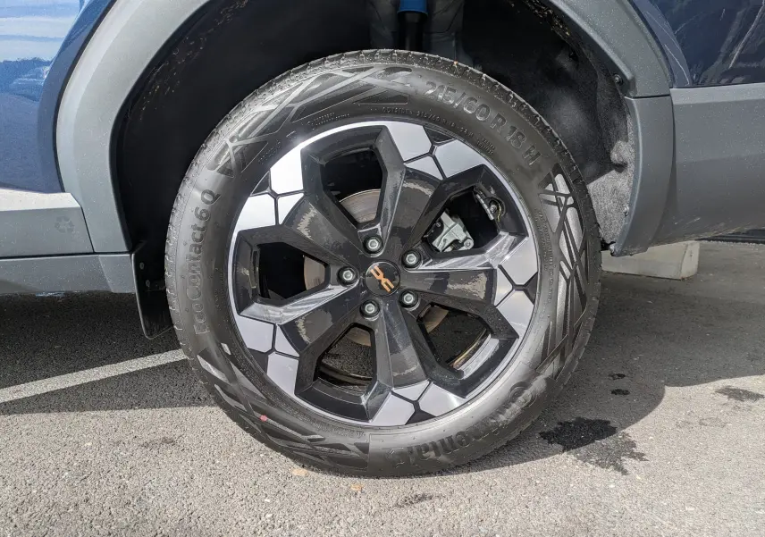 Gros plan sur la roue avant gauche du Dacia Bigster Hybrid 155 Extreme bleu indigo avec jante alliage diamantée 18 pouces.