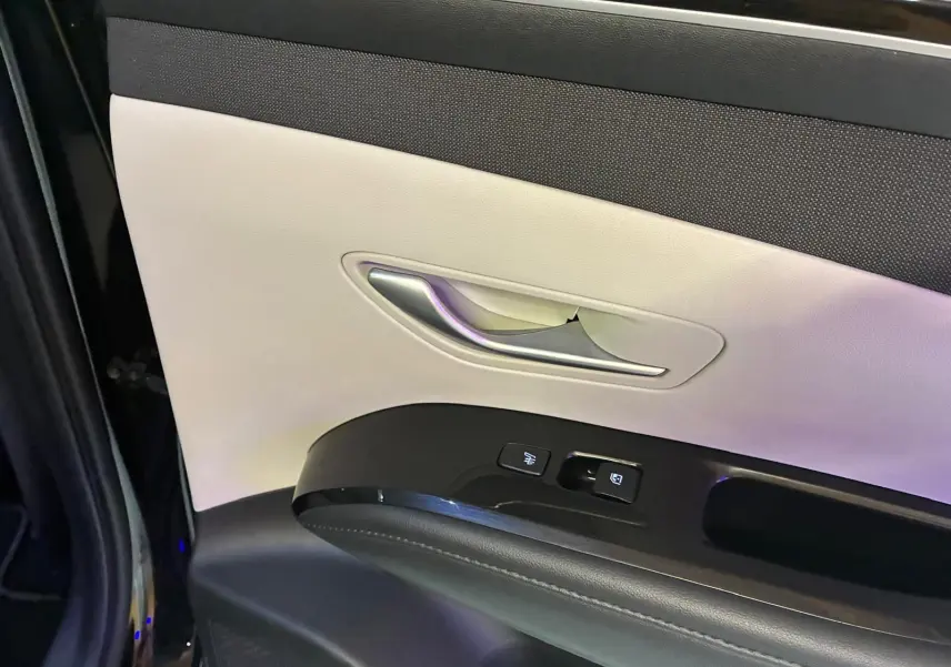Détail de la porte avant gauche du Hyundai Tucson noir 2022, montrant la poignée argentée et les commandes électriques.