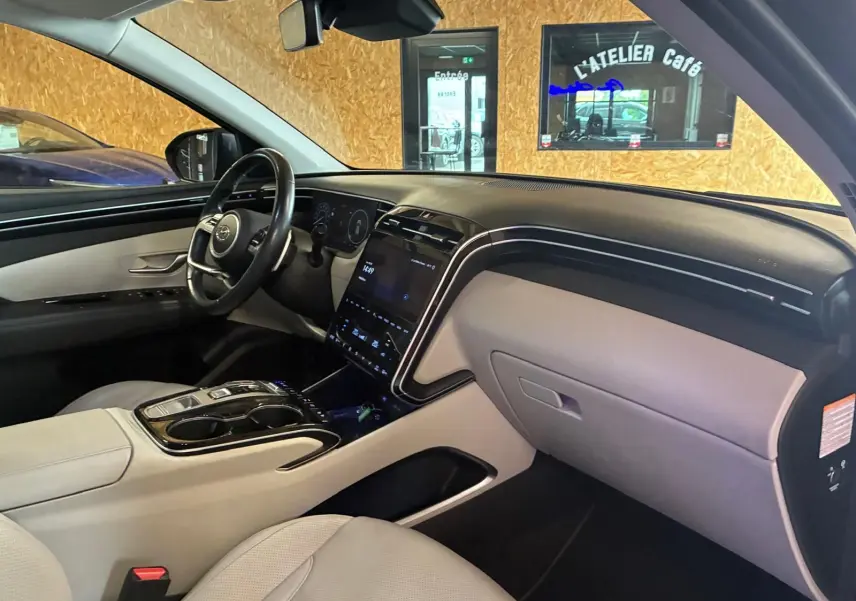 Vue intérieure côté passager du Hyundai Tucson 1.6 T-GDI Hybrid 230 Executive 2022, tableau de bord beige et noir moderne.