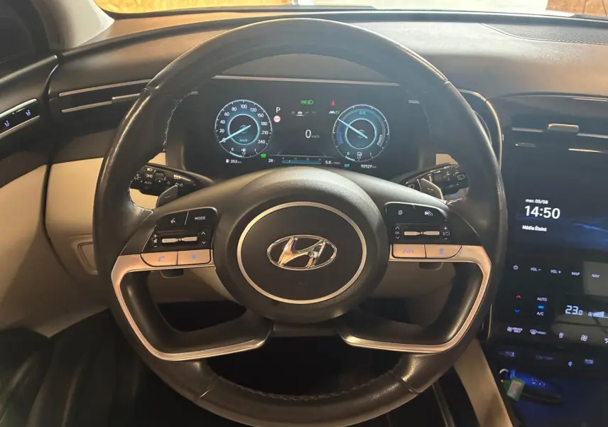Vue intérieure centrée sur le volant noir du Hyundai Tucson 2022 avec tableau de bord numérique et console tactile.