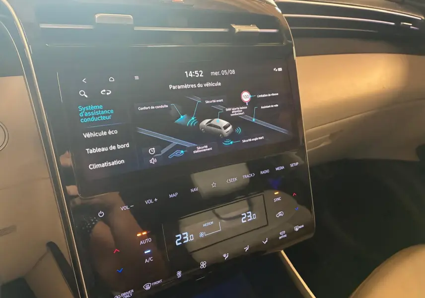 Vue rapprochée de l’écran tactile central noir du Hyundai Tucson 2022, affichant les paramètres d’assistance conducteur.