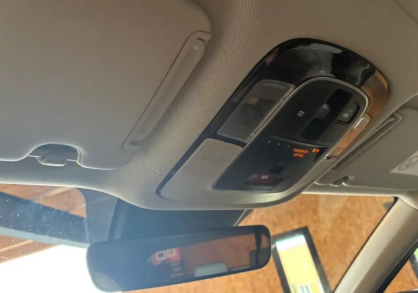 Vue intérieure du plafond avant du Hyundai Tucson noir 2022, avec commandes d'éclairage et rétroviseur central visible.