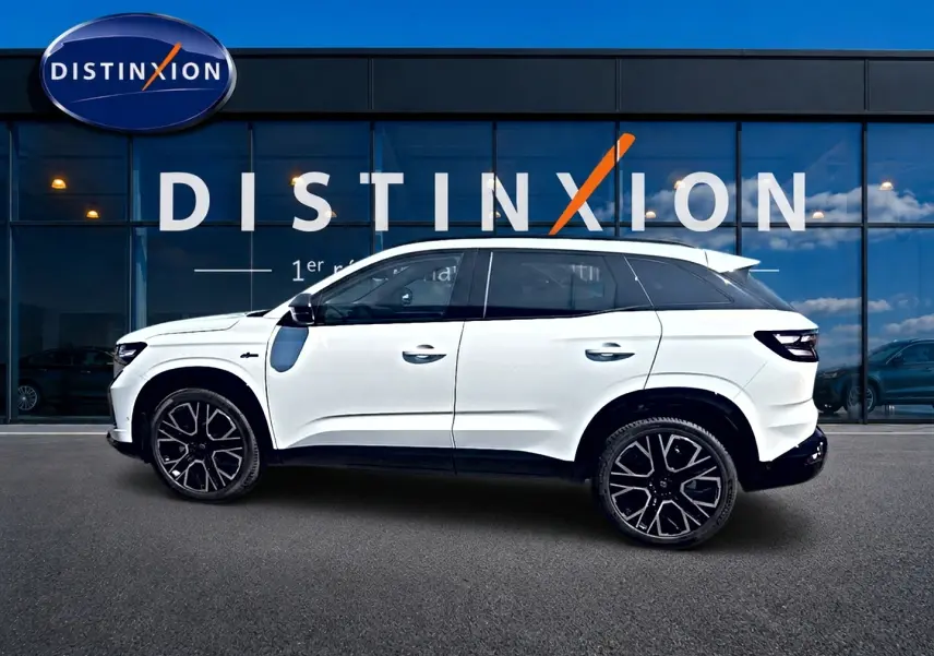 Renault Austral blanc nacré en profil droit, jantes alu noires et toit contrasté devant vitrine Distinxion.