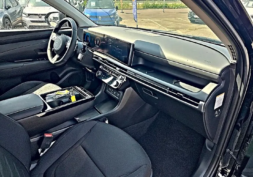 Vue intérieure côté conducteur du Hyundai Tucson noir 2026, avec tableau de bord moderne et écran tactile large.