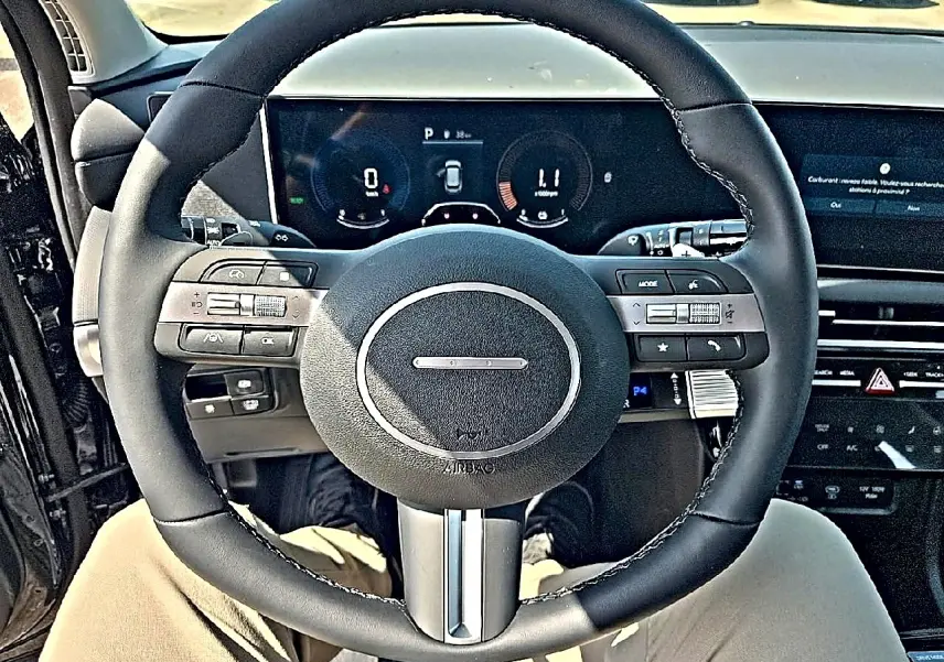 Vue intérieure centrée sur le volant cuir multifonction noir du Hyundai Tucson 2026 avec tableau de bord numérique.