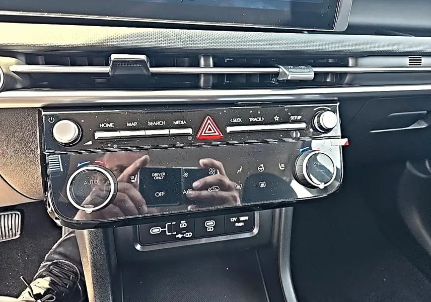 Vue rapprochée du tableau de bord noir du Hyundai Tucson 2026, avec commandes climatisation et multimédia.