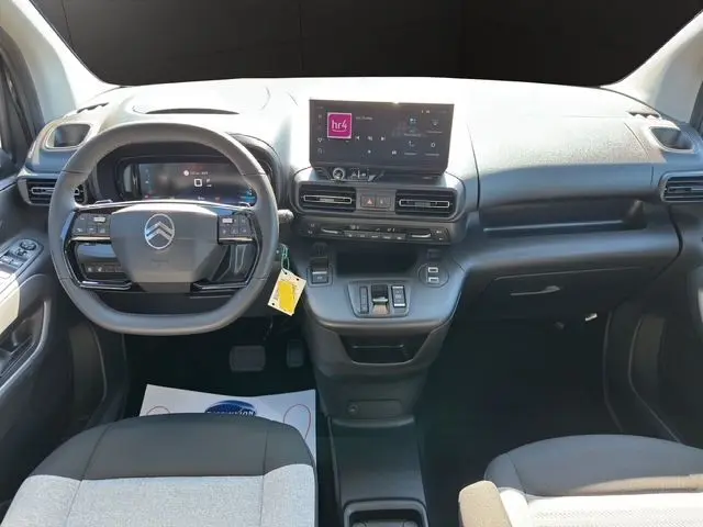 Intérieur avant droit du Citroën Berlingo noir 2025, tableau de bord moderne avec écran tactile et sièges bicolores gris et noir.