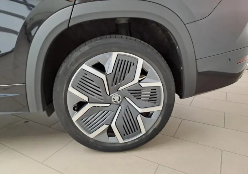 Gros plan sur la roue arrière droite du Skoda Kodiaq noir Magic nacré avec jante alliage 20'' Rila anthracite.
