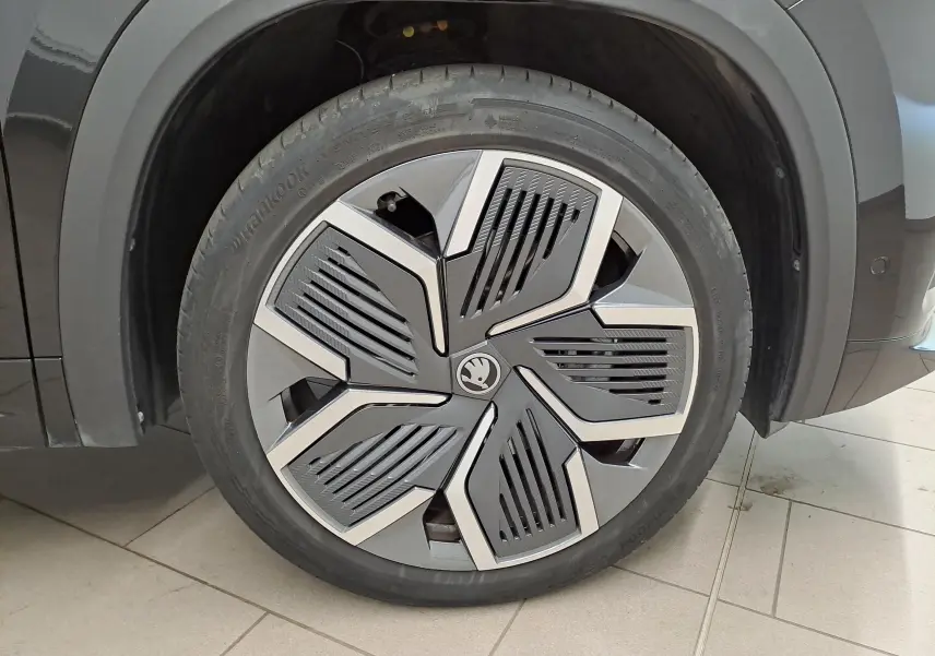 Gros plan sur la roue avant gauche du Skoda Kodiaq noir Magic nacré avec jante alliage 20'' Rila anthracite.