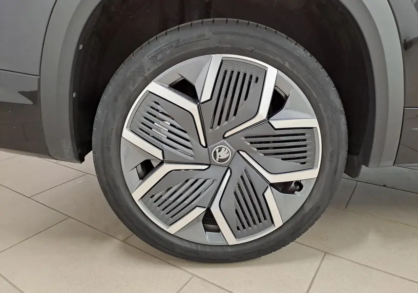 Gros plan sur la jante alliage 20'' Rila anthracite avec enjoliveurs noirs du côté gauche d’un Skoda Kodiaq Noir Magic nacré.