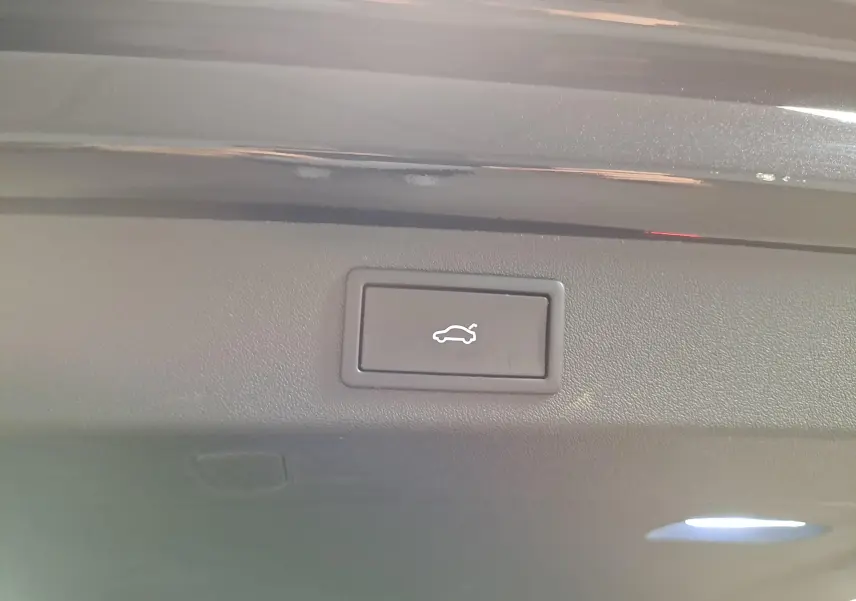 Bouton d'ouverture électrique du hayon sur la partie intérieure du coffre d'un Skoda Kodiaq Noir Magic nacré.