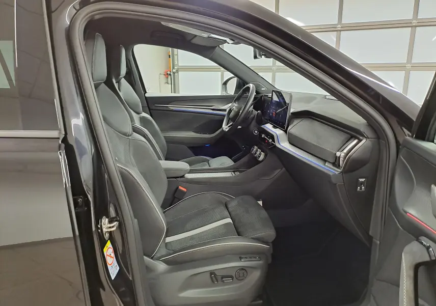 Intérieur côté conducteur du Skoda Kodiaq noir Magic nacré, sièges sport, tableau de bord moderne avec écran tactile.
