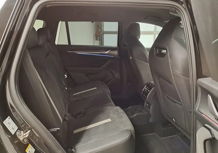 Vue intérieure côté gauche des sièges arrière noirs avec surpiqûres claires du Skoda Kodiaq 2025 finition Sportline.