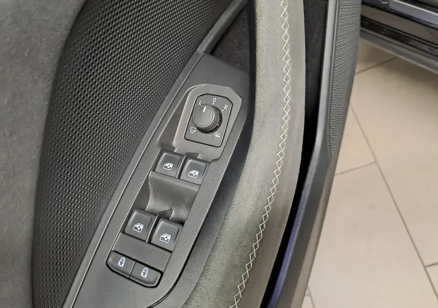 Gros plan sur les commandes de vitres et rétroviseurs côté gauche de la porte intérieure du Skoda Kodiaq noir Magic nacré.