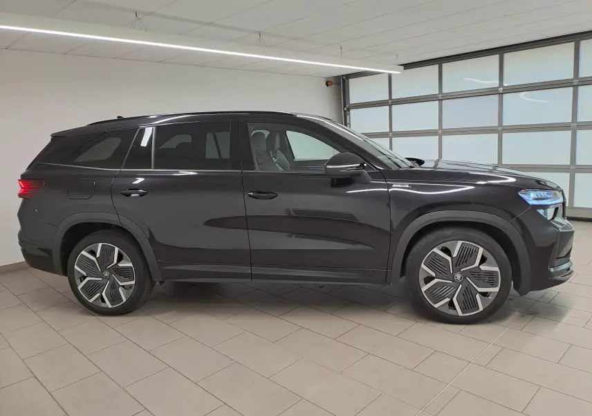 Vue latérale droite du Skoda Kodiaq 2025 noir Magic nacré avec jantes alliage 20'' Rila anthracite et phares LED allumés.