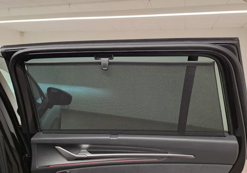 Vue intérieure de la porte arrière gauche d’un Skoda Kodiaq noir Magic Nacré avec pare-soleil intégré.