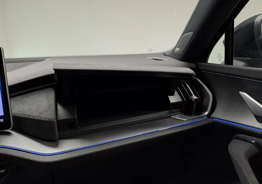 Intérieur du Skoda Kodiaq 2025, vue côté passager sur boîte à gants ouverte et éclairage d'ambiance bleu.