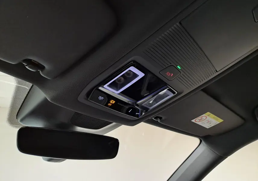 Plafonnier intérieur avec commandes lumineuses et bouton SOS, vue du poste de conduite du Skoda Kodiaq noir Magic nacré 2025.