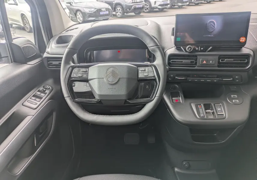 Vue intérieure frontale du tableau de bord et volant noir du Citroën Berlingo 2025 avec écran tactile et commandes intégrées.