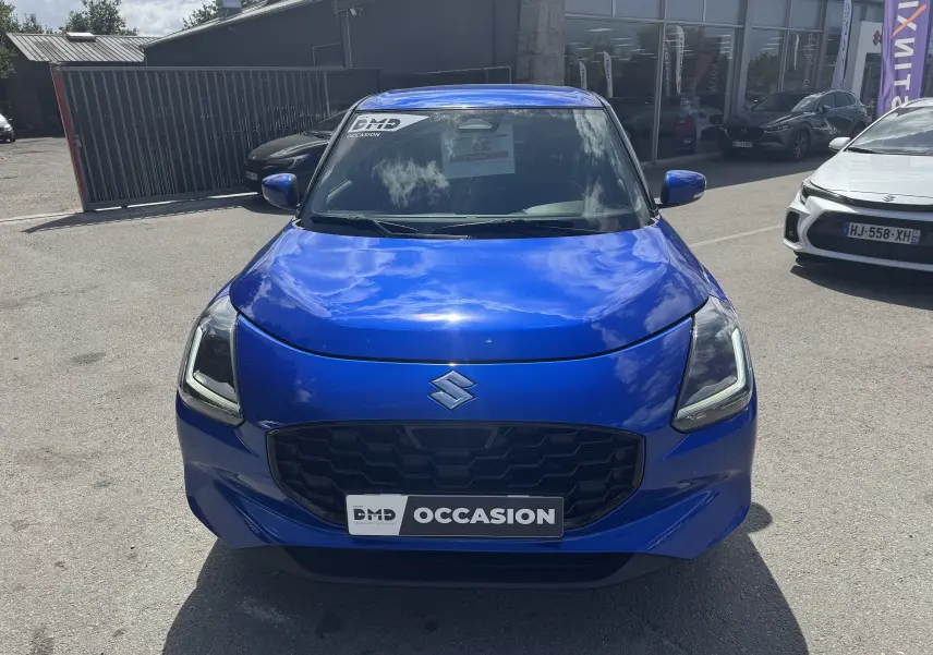 Vue avant d'une Suzuki Swift 1.2 Pack Hybrid bleu vif, avec calandre noire et badge Suzuki bien visible.