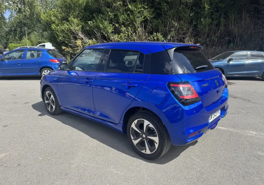 Suzuki Swift 1.2 Pack Hybrid bleu vue 3/4 arrière droit, avec toit noir et jantes au design bicolore.