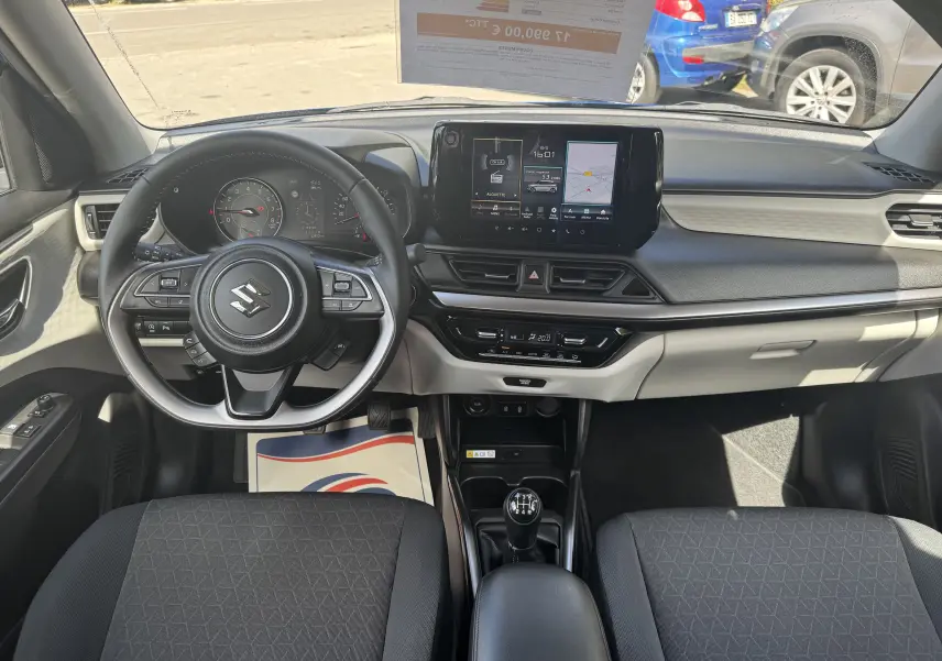 Vue intérieure avant de la Suzuki Swift 1.2 Pack Hybrid 2024, avec tableau de bord moderne et écran tactile central.