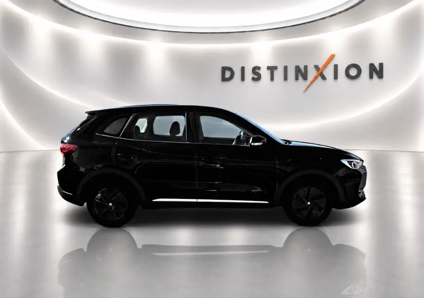 Profil droit du MG ZS 1.5 hybrid noir 2026 avec jantes noires, posé dans un studio lumineux au mur blanc.