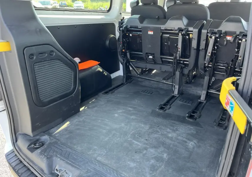 Vue arrière intérieure du Ford Transit Custom blanc montrant l'espace de chargement et les sièges rabattus.