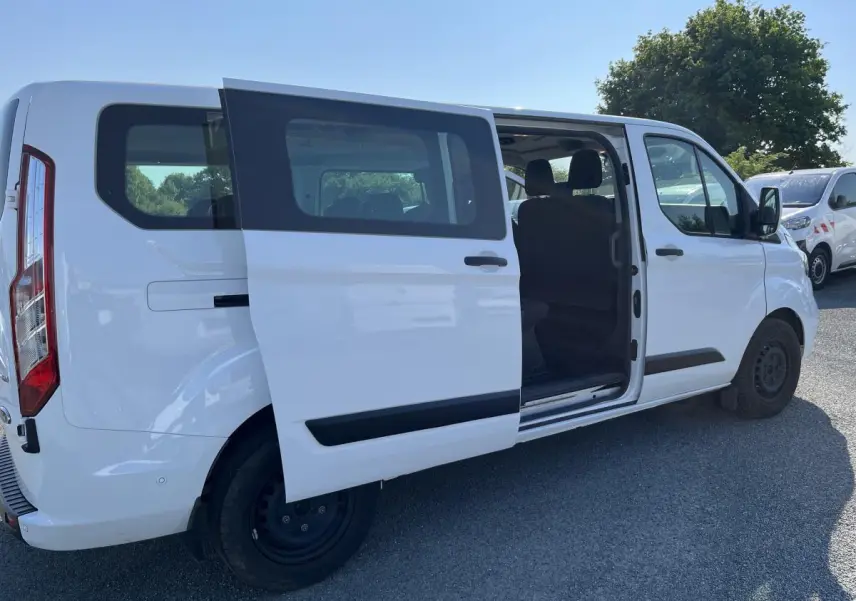 Ford Transit Custom Kombi blanc vu de côté droit avec porte coulissante ouverte montrant l'intérieur des sièges.