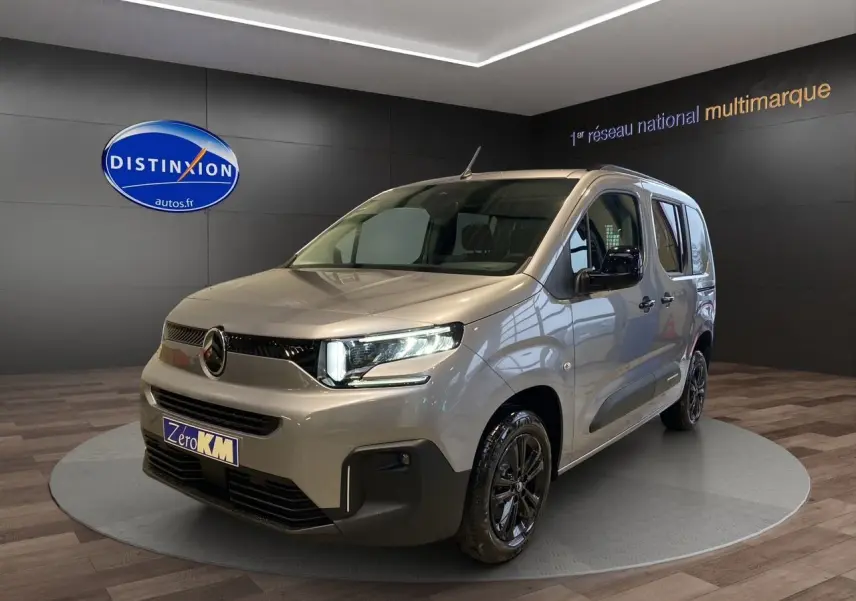 Citroën Berlingo 2025 gris Artense en 3/4 avant droit avec jantes noires et feux LED allumés.