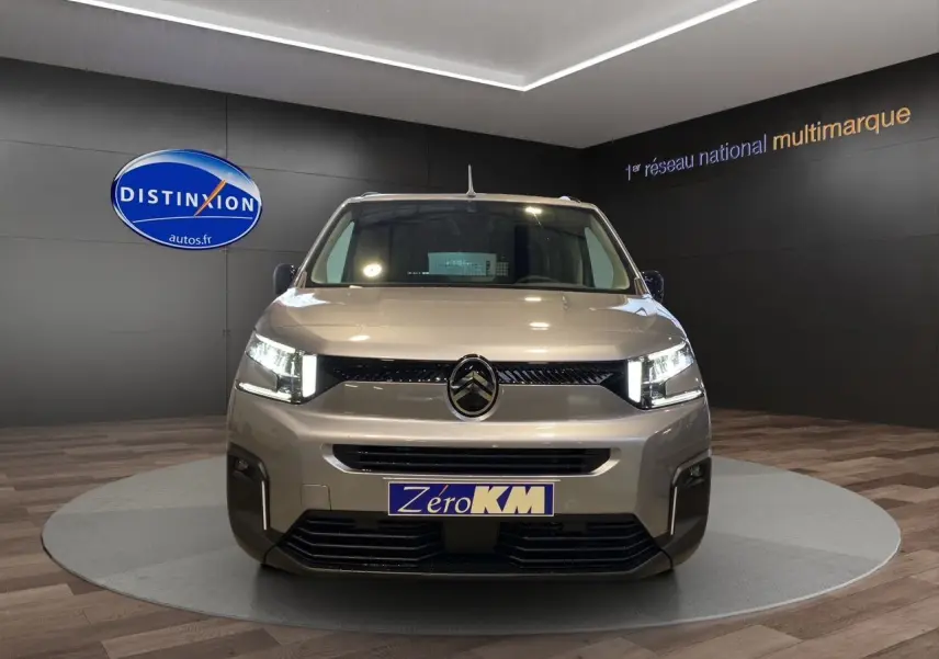 Vue de face du Citroën Berlingo gris Artense 2025 avec phares allumés et calandre noire brillante.