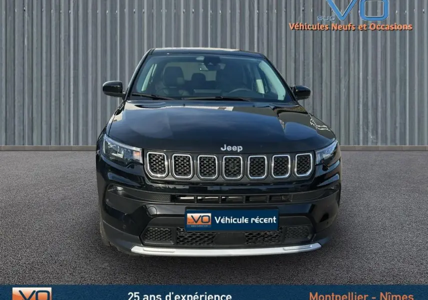 Vue frontale d'un Jeep Compass noir 2024 avec calandre à sept fentes et phares LED allumés.