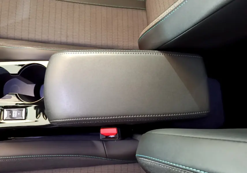 Vue rapprochée de l'accoudoir central noir et des sièges gris clair avec surpiqûres bleues du Peugeot 2008 2021.