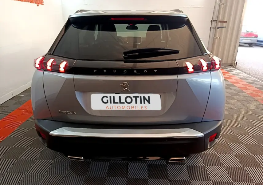 Vue arrière d'un Peugeot 2008 gris clair avec feux LED caractéristiques et logo au centre du hayon.