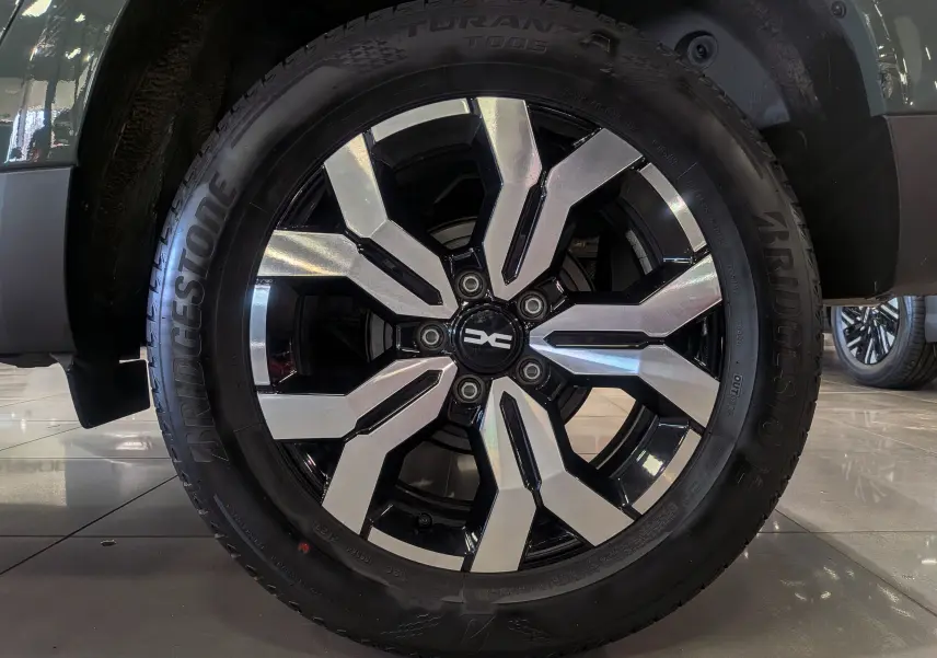 Gros plan sur la jante alliage bicolore noir et argent du Dacia Duster 2023 en couleur Kaki Lichen.