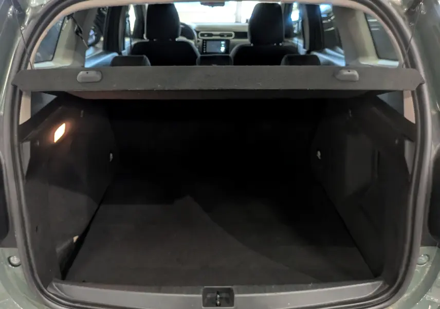 Coffre ouvert du Dacia Duster 2023 Kaki Lichen, vue arrière montrant l’espace de chargement et l’intérieur sombre.