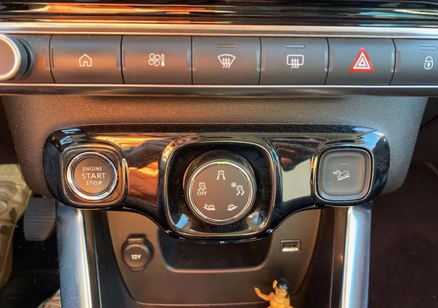 Gros plan sur la console centrale du Citroën C3 Aircross gris foncé 2024, avec boutons de démarrage et contrôle Grip Control.