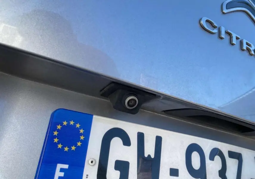 Gros plan sur la caméra de recul au-dessus de la plaque d’immatriculation d’un Citroën C3 Aircross gris foncé.