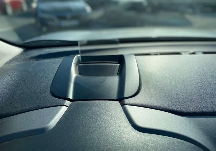 Détail du tableau de bord noir du Citroën C3 Aircross 2024 avec écran escamotable au centre, vue intérieure frontale.