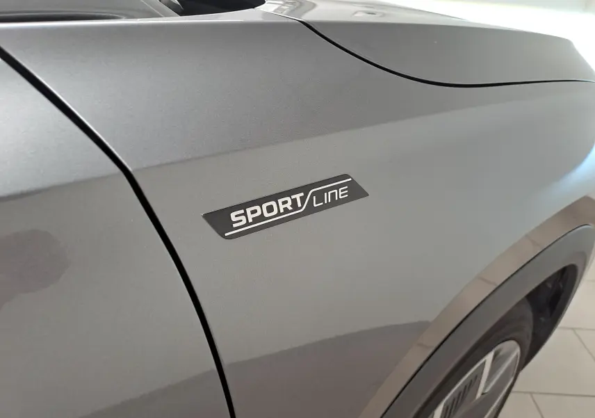 Gros plan sur l'aile avant droite gris graphite du Skoda Kodiaq 2025 avec badge Sportline visible.