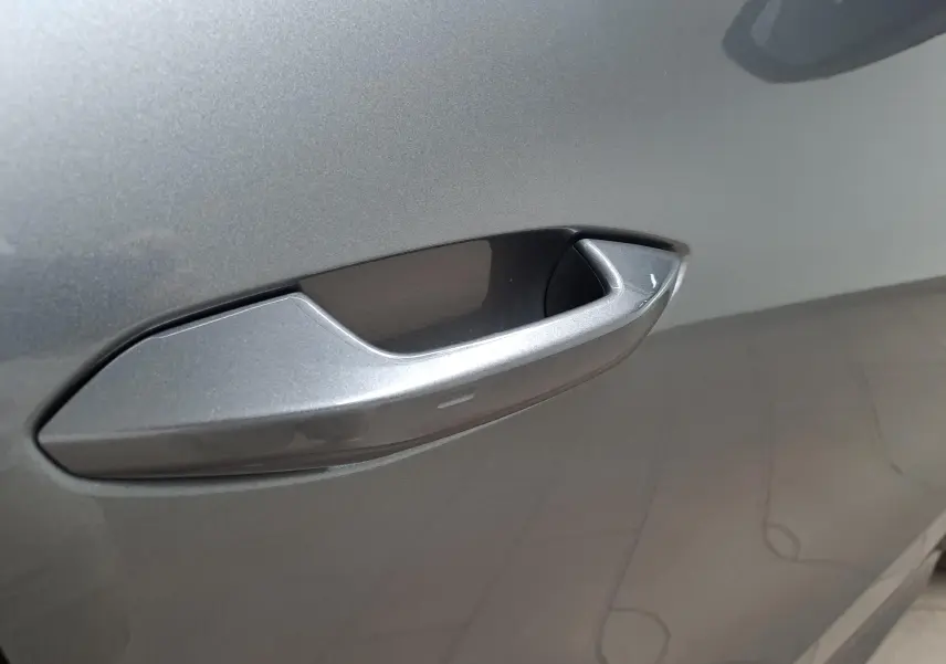 Poignée de porte gris graphite en gros plan sur le côté gauche du Škoda Kodiaq 2025 hybride rechargeable.