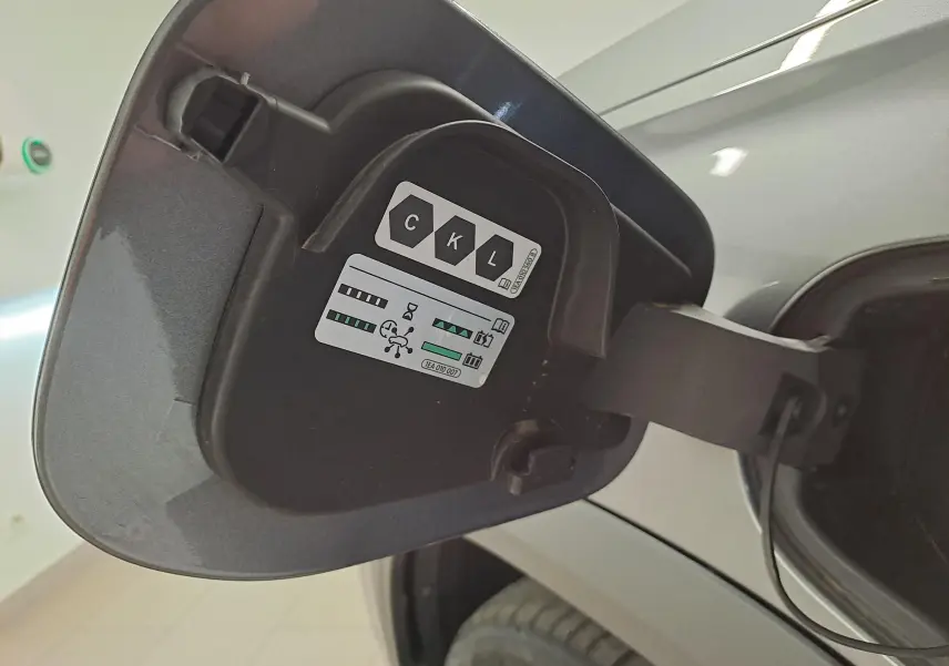 Gros plan sur la trappe de recharge côté gauche du Skoda Kodiaq gris graphite, version hybride rechargeable 2025.